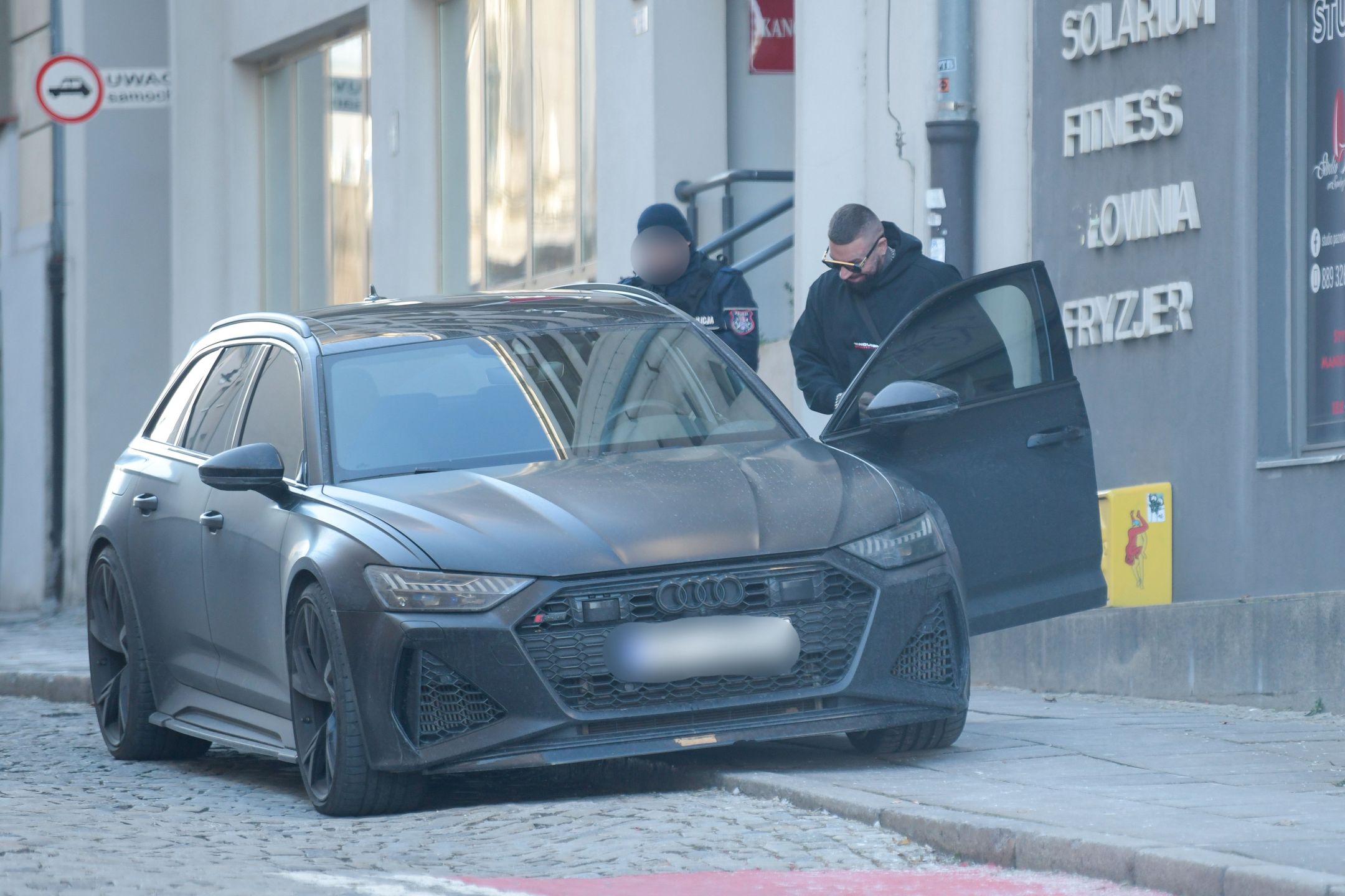 Uśmiechnięty Daniel Majewski wsiada do samochodu za ponad 600 tysięcy