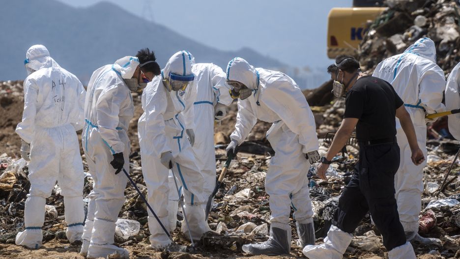 Police officers dress in PPEs searching a part of the Landfill for Evidence in a murder case on February 28, 2023 in Hong Kong, China. Over 100 police officers search for the missing torso and arms of murdered and dismembered Hong Kong socialite and model Abby Choi Tin-fung in a Landfill in the New Territories. (Photo by Vernon Yuen/NurPhoto via Getty Images)