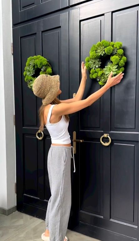 Rozenek poprawia wianki na drzwiach