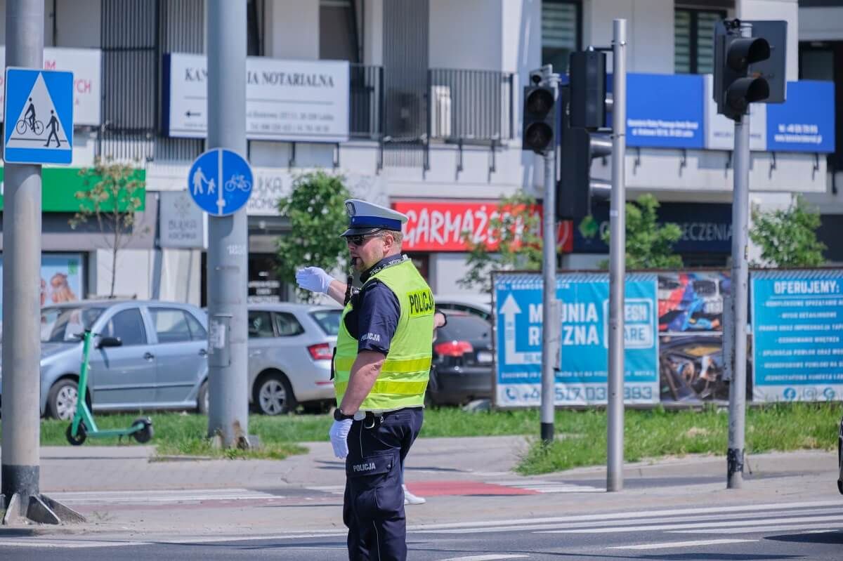 Policjant kierujący ruchem na skrzyżowaniu z wyłączoną sygnalizacją świetlną
