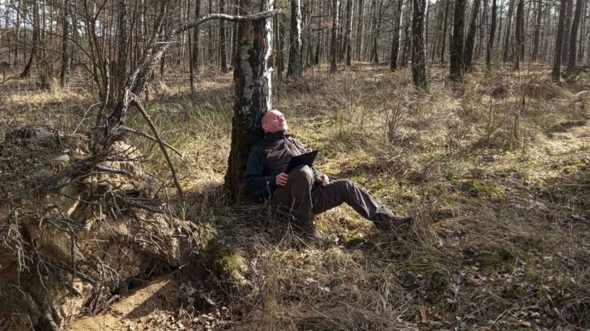 Nietypowe zdjęcie z lasu. Leśnik leży pod drzewem