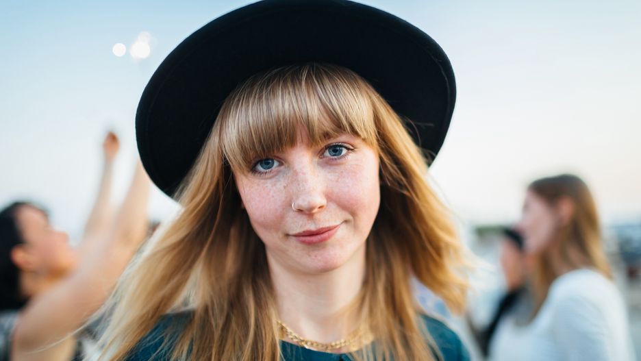Młoda kobieta o blond włosach w kapeluszu.