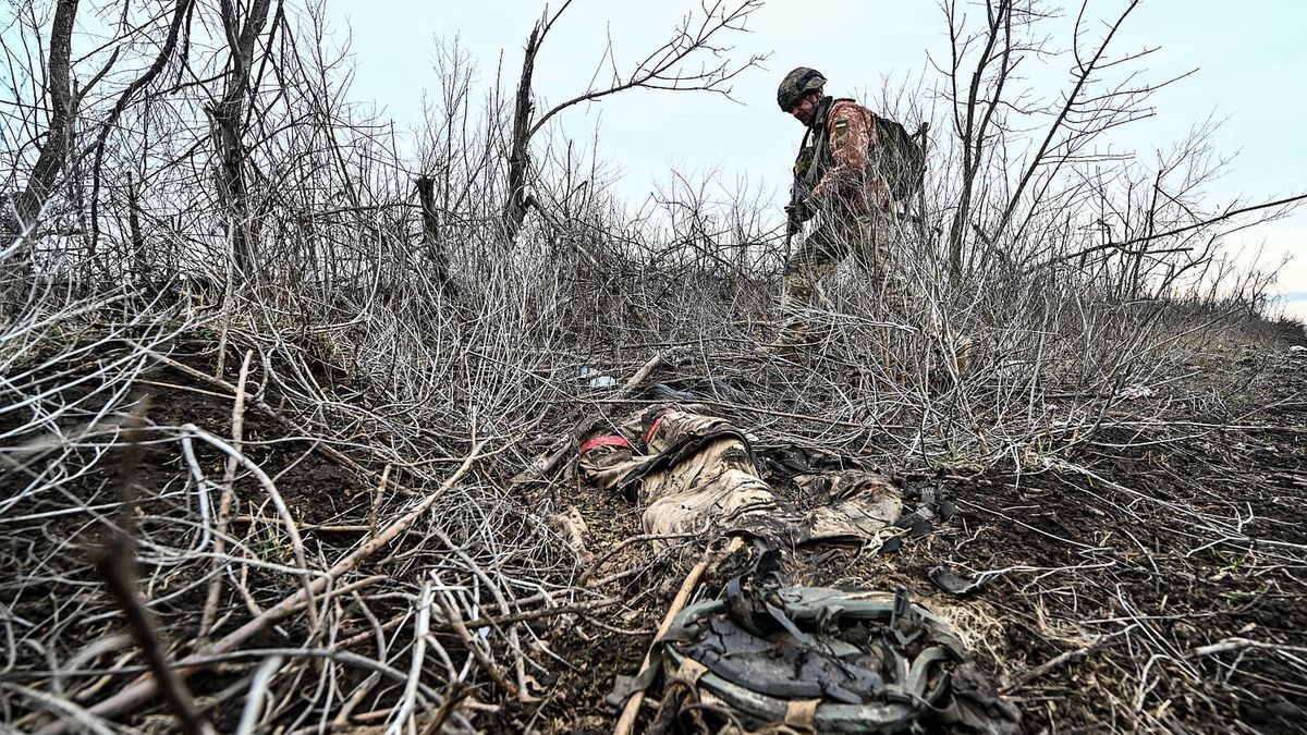 Ukraiński żołnierz mija pozostałości mundury żołnierza rosyjskie