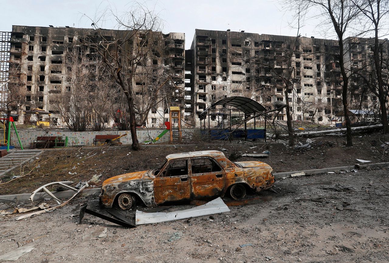 Spalony samochód i budynki po ataku wojsk rosyjskich na Mariupol.