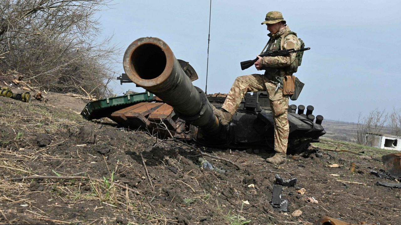 Ukraiński żołnierz przy wieży oderwanej od rosyjskiego czołgu
