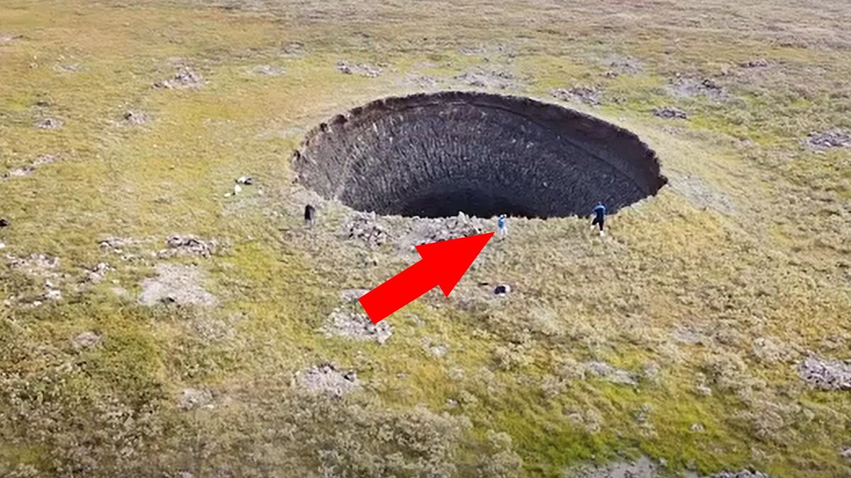 Jeden z syberyjskich kraterów. Strzałka pokazuje człowieka obecnego dla porównania skali