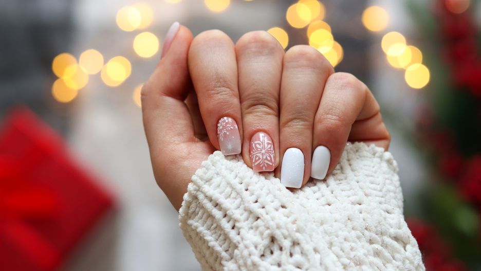 Idea of the winter manicure. Woman's hand with gel polish manicure white color and with snowflakes ornament against festive Christmas background. Selective focusIdea of the winter manicure. Woman's hand with gel polish manicure white color and with snowflakes ornament against festive Christmas background. Selective focus.winter, manicure, art, female, nails, design, festive, snowflake, gel, polish, elegance, christmas, beauty, finger, beautiful, shiny, skin, idea, glitter, square, style, gel polish, tan, woman, women, snow, nail, color, decoration, holiday, hand, fingernail, short, background, elegant, holidays, xmas, colors, closeup, clean, cozy, selective focus, winter, manicure, art, female, nails, design, festive, snowflake, gel, polish, elegance, christmas, beauty, finger, beautiful, shiny, skin, idea, glitter, square, style, gel polish, tan, woman, women, snow, nail, color, decoration, holiday, hand, fingernail, short, background, elegant, holidays, xmas, colors, closeup, clean, cozy, selective focus