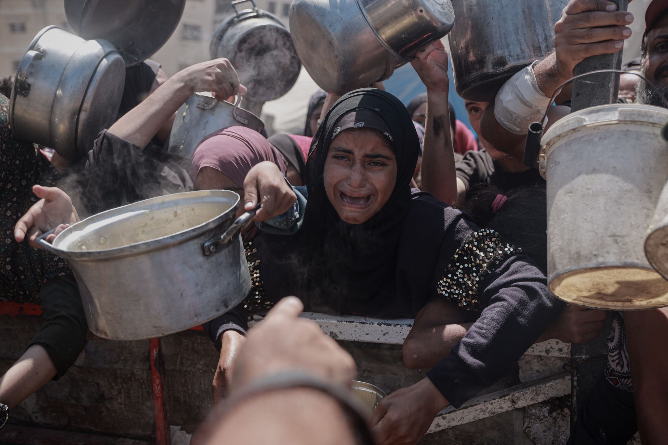Palestyńczycy czekający na jedzenie w Strefie Gazy