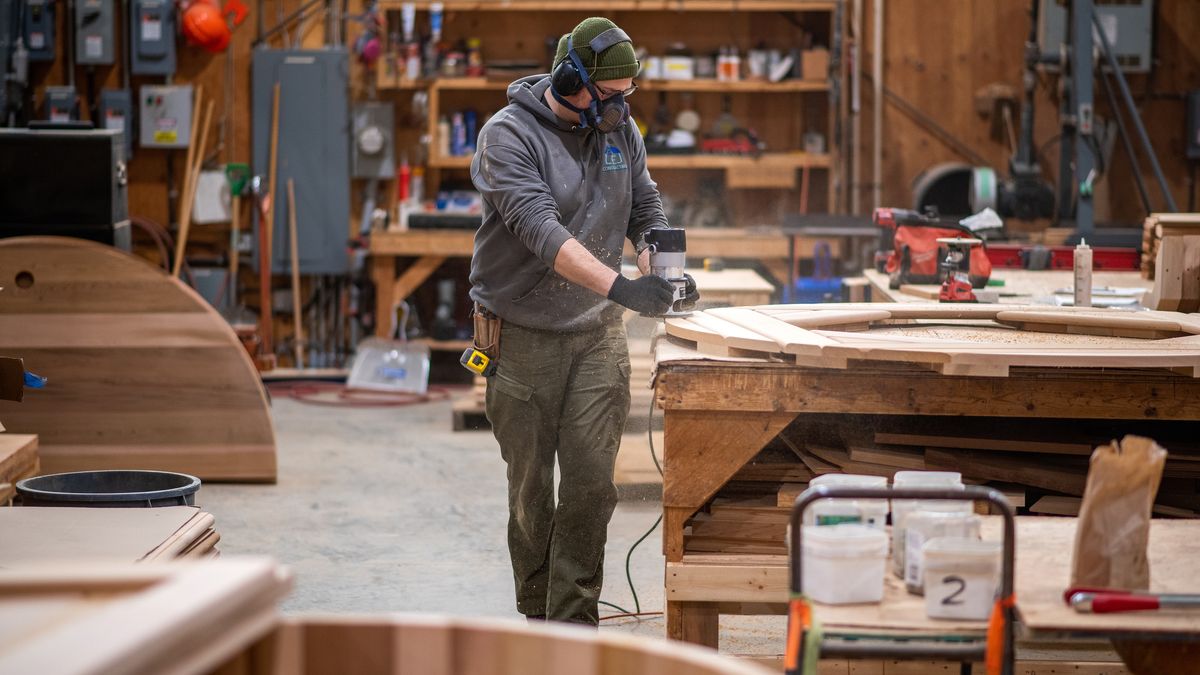 A worker routers the edge of a seat for a circular hot tub on the manufacturing floor at Forest Cooperage near Sooke, British Columbia, Canada, on Friday, Feb. 24, 2023. Forest Cooperage Inc. uses locally milled Western Red Cedar wood to manufacture hot tubs, barrel saunas, and water cisterns. Photographer: James MacDonald/Bloomberg via Getty Images