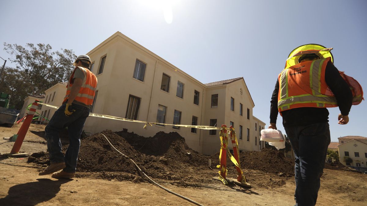 LOS ANGELES, CA -  JUNE 23, 2022 - - Construction workers walk past Building 207 that is being refurbished as housing for veterans on the Veteran Affairs West LA campus in Los Angeles on June 23, 2022. This is the  Collectives first project, a 60-unit building for senior veterans and their families and is scheduled to open this fall.  Along with U.S. VETS, the Collective is made up of Century Housing, a nonprofit that builds and finances affordable housing, and Thomas Saffran and Associates, a Brentwood-based for-profit affordable housing developer. The master plan calls for 14 buildings to be brought up to current standards but preserved in their original form with another 14 built from the ground up. (Genaro Molina / Los Angeles Times via Getty Images)