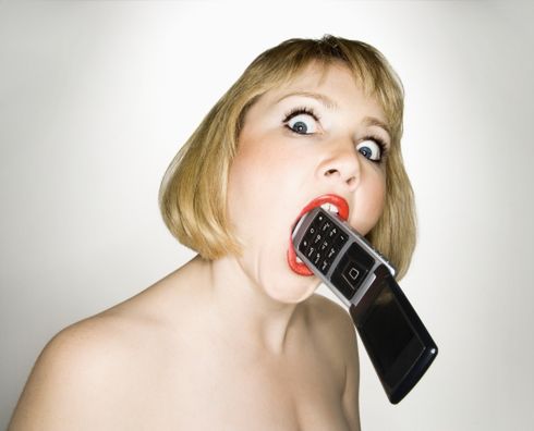 Crazy woman biting phone.