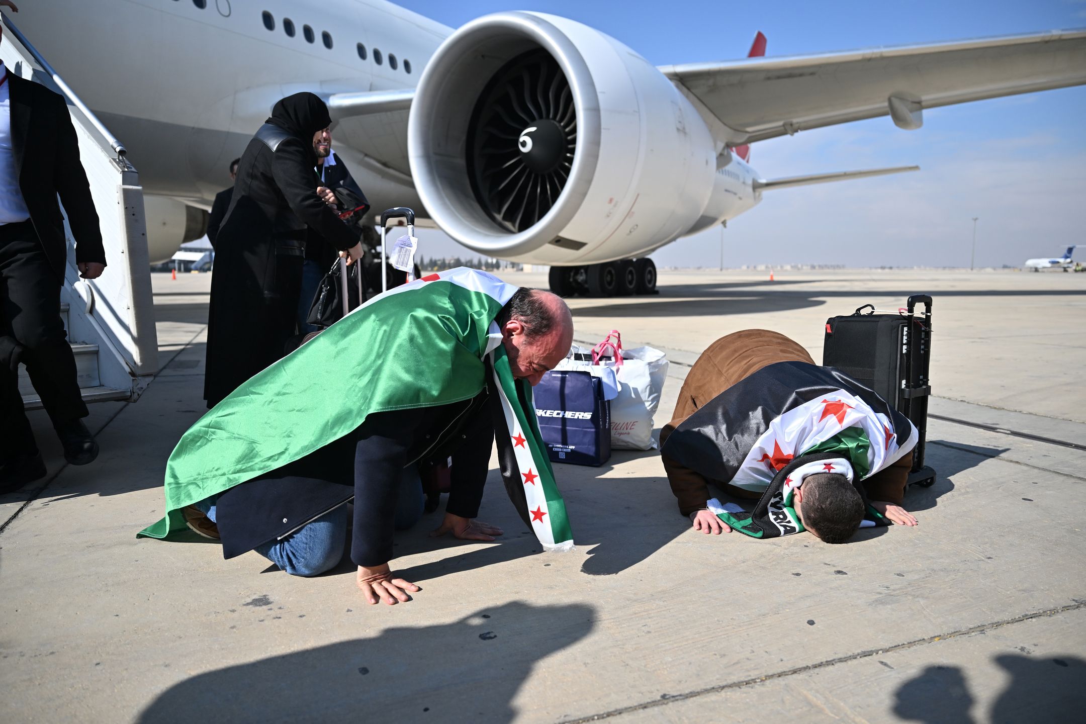 DAMASCUS, SYRIA - JANUARY 23: Syrians celebrate landing on Damascus International Airport as Turkish Airlines operates its first flight to Syria after 13 years, after halting operations in 2012, due to the country's civil war, in Damascus, Syria on January 23, 2025. (Photo by Isa Terli/Anadolu via Getty Images)