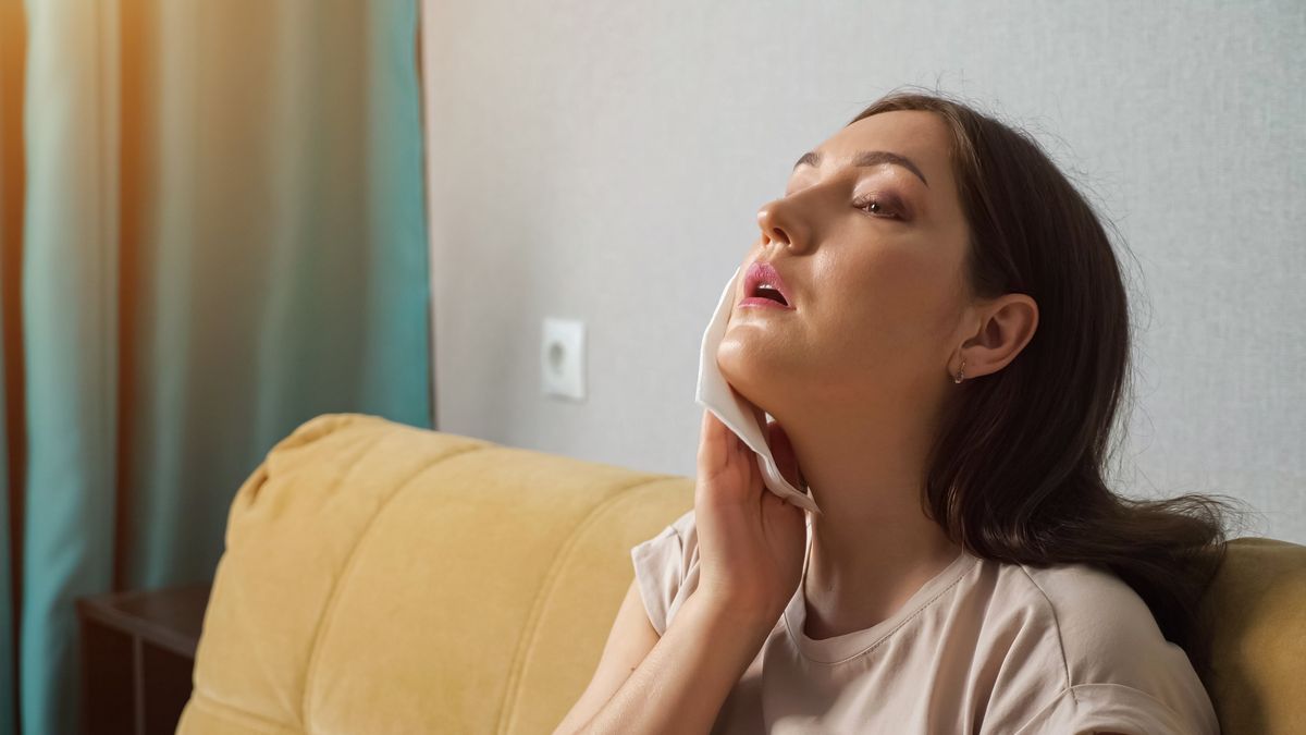 Brunette woman suffering from the heat, wiping herself off with a paper napkinBrunette woman suffering from the heat, wiping herself off with a paper napkin, sunlightLENblR