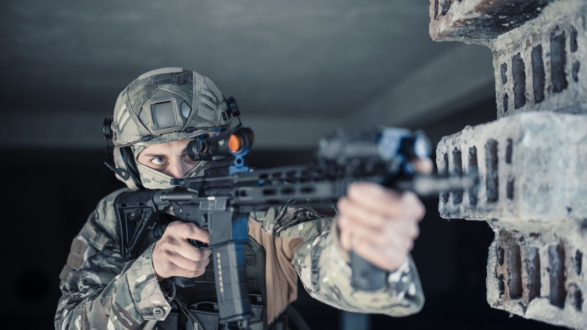 Professional soldier escape from the building in war zone.