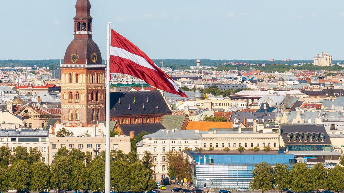 Łotewska flaga na tle panoramy Rygi