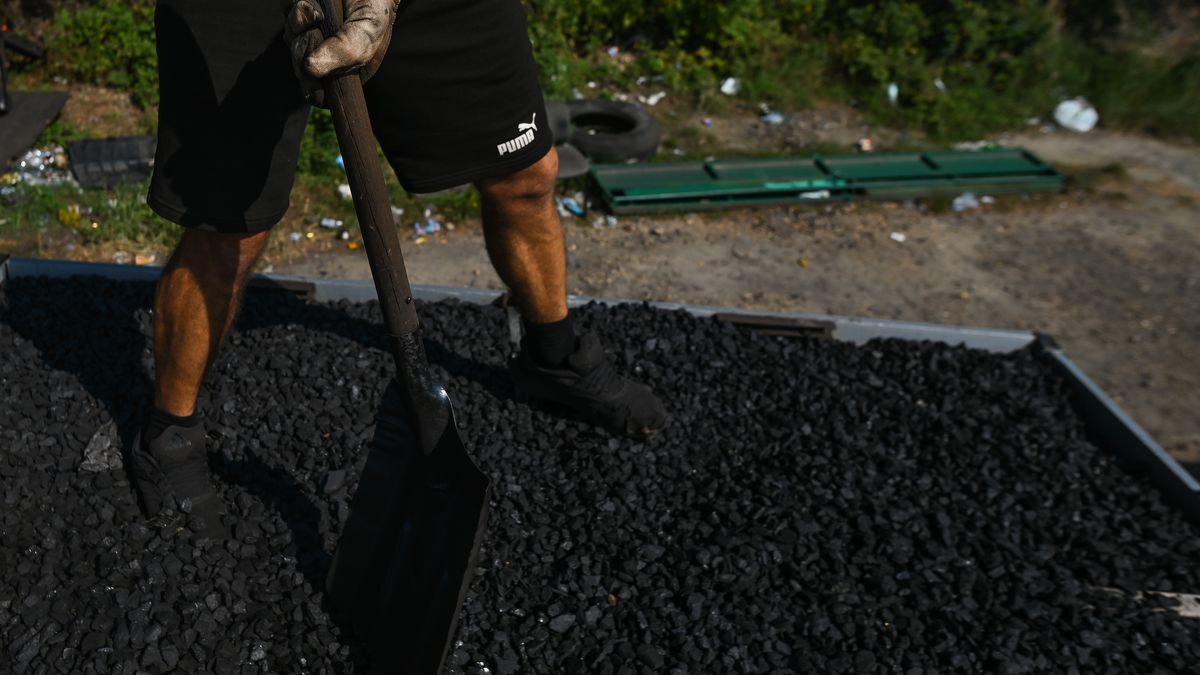 JAWORZNO, POLAND - SEPTEMBER 08: A man levels the coal before covering the trailer parked outside the Sobieski coal mine. The energy crisis is slowly heating up in Poland. The lack of coal in the Polish market is due to the decarbonization process: when domestic production was reduced and the market needs were supplemented with imports from Russia, which, following the introduction of the embargo on Russian coal, resulted in an 8 million tonne deficit causing coal shortages and price rises. Customers can buy coal directly from the mine, but must must subscribe to a waiting list and will be called upon to pick up the coal after a couple of weeks. The limit is three tonnes per buyer, with his own transport. Buyers wait in line for up to several days to complete the formalities, but many are attracted by the price: PLN 1,450 per ton of coal compaired to PLN 3,200-3,800 in warehouses. (Photo by Artur Widak/Anadolu Agency via Getty Images)