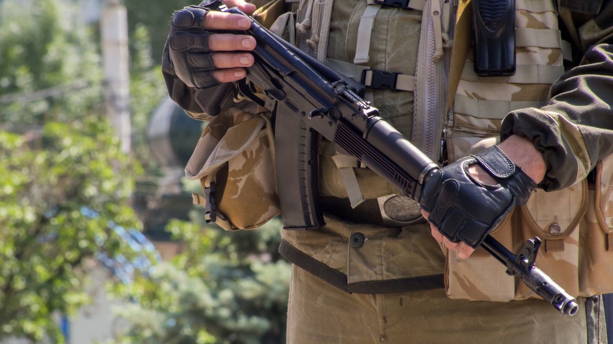 Midsection Of Army Soldier Holding Rifle Against Cloudy SkyIgor Golovnov / EyeEmofficer, hand glove