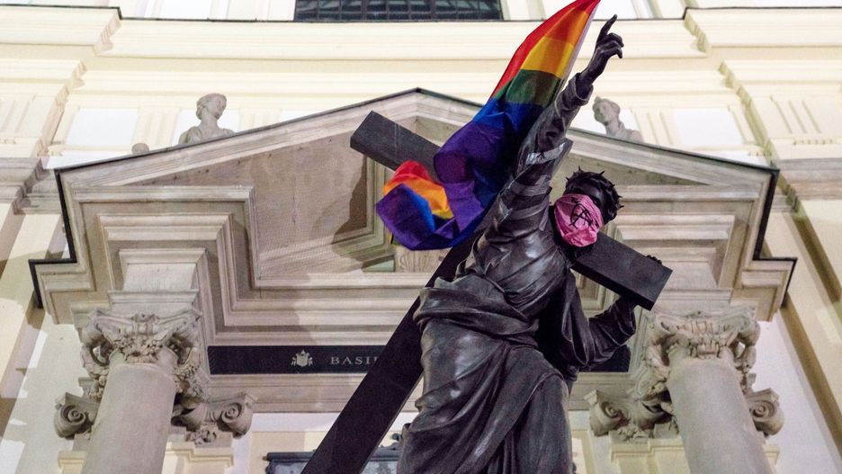 Tęczowe flaga LGBT na warszawskim pomniku przed Bazyliką św. Krzyża na Krakowskim Przedmieściu