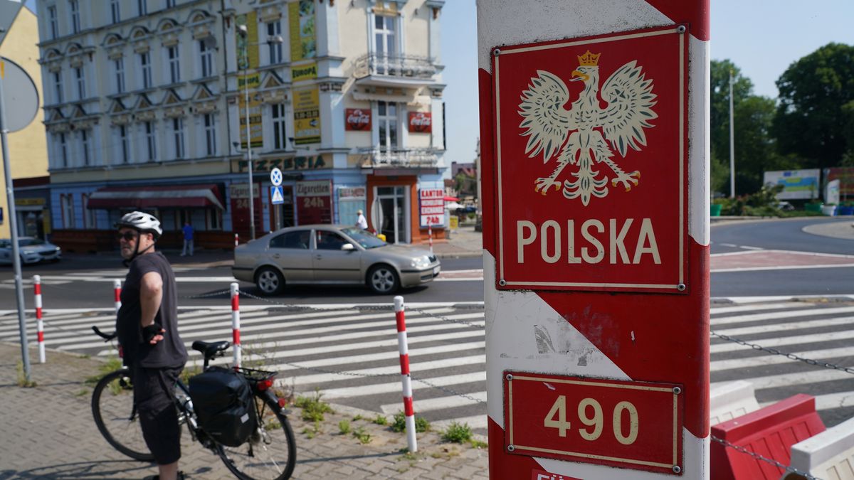 SLUBICE, POLAND - JUNE 13: A cyclist from Germany stands near a Polish border markler hours after Polish authorities reopened the nearby border during the novel coronavirus pandemic on June 13, 2020 in Slubice, Poland. Poland lifted restrictions on its border crossings to Germany, Austria and Slovakia starting at midnight, last night that had been in place since March to stem the spread of the virus. (Photo by Sean Gallup/Getty Images)