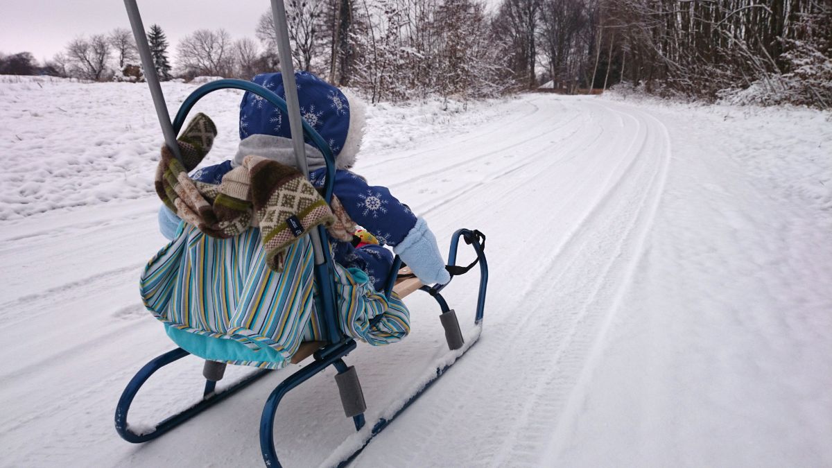 Dziecko jedzie na sankach.