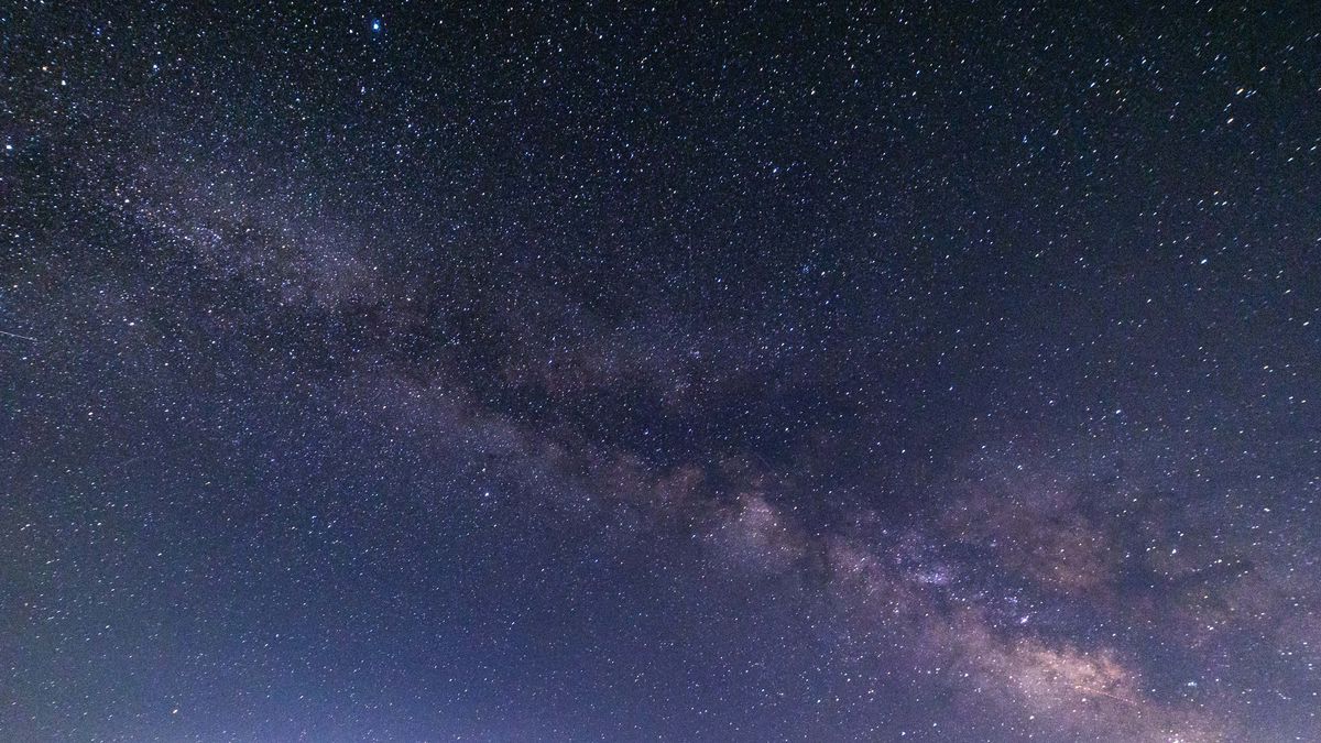 Milky Way captured with long exposure photography technique. Milkyway is the visible part of our galaxy seen during the dark night from the mountain area near Xanthi city in Northern Greece. Night landscape over the mountain with colourful Milky Way sky dome, the cloudless sky at mountains with the starry sky with hills at summer with the beautiful Universe and Space background. The Milky Way is a barred spiral galaxy the galaxy that includes the Solar System, with the name describing the galaxy appearance from Earth, a hazy band of light seen in the night sky formed from stars. The lines appearing are aircraft passing, satellite and meteorites while the lower light pollution comes from the city lights. Xanthi, Thrace, Greece on July 2024 (Photo by Nicolas Economou/NurPhoto via Getty Images)