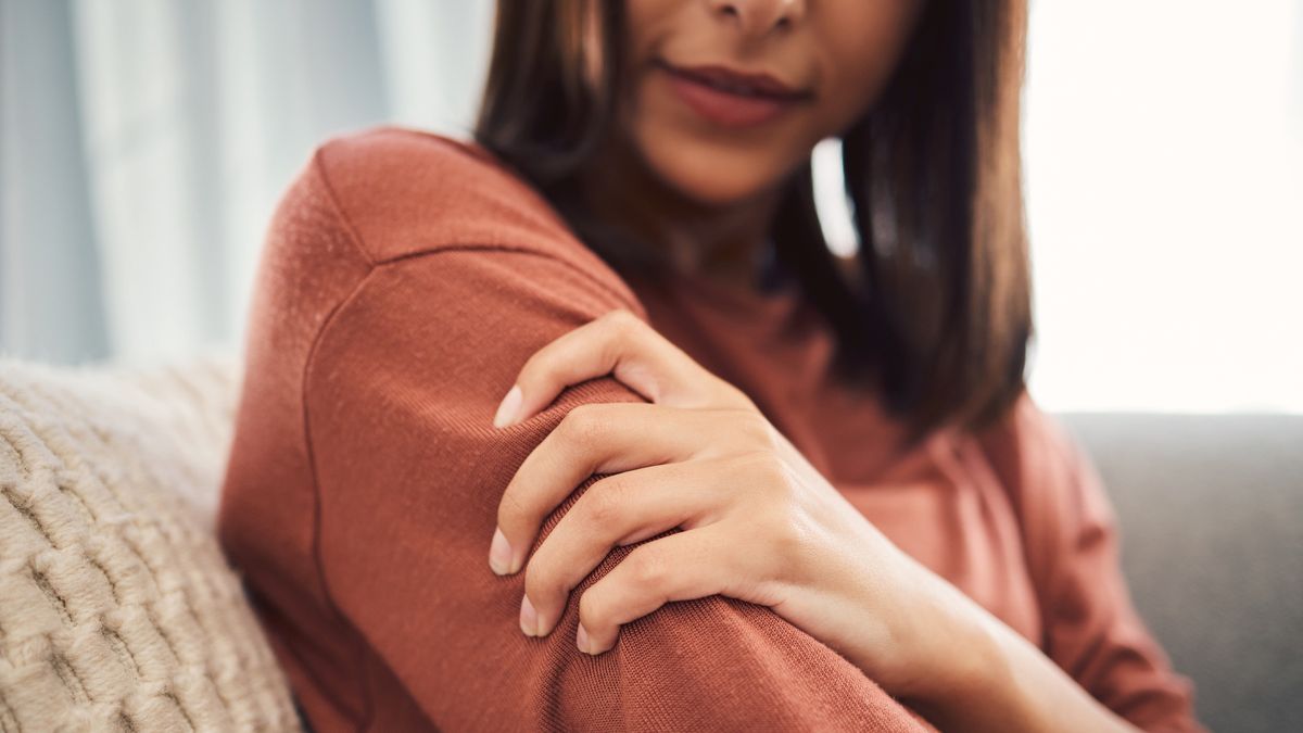 Close up of a young woman holding her arm and suffering with pain while sitting in the living room at home. Mixed race woman holding her arm in pain due to injury or arthritis
Closeup shot of a mixed race woman in casual wear holding her arm while suffering pain and sitting on her sofa in the lounge at home. One unrecognizable female struggling with an injury and arthritis
PeopleImages