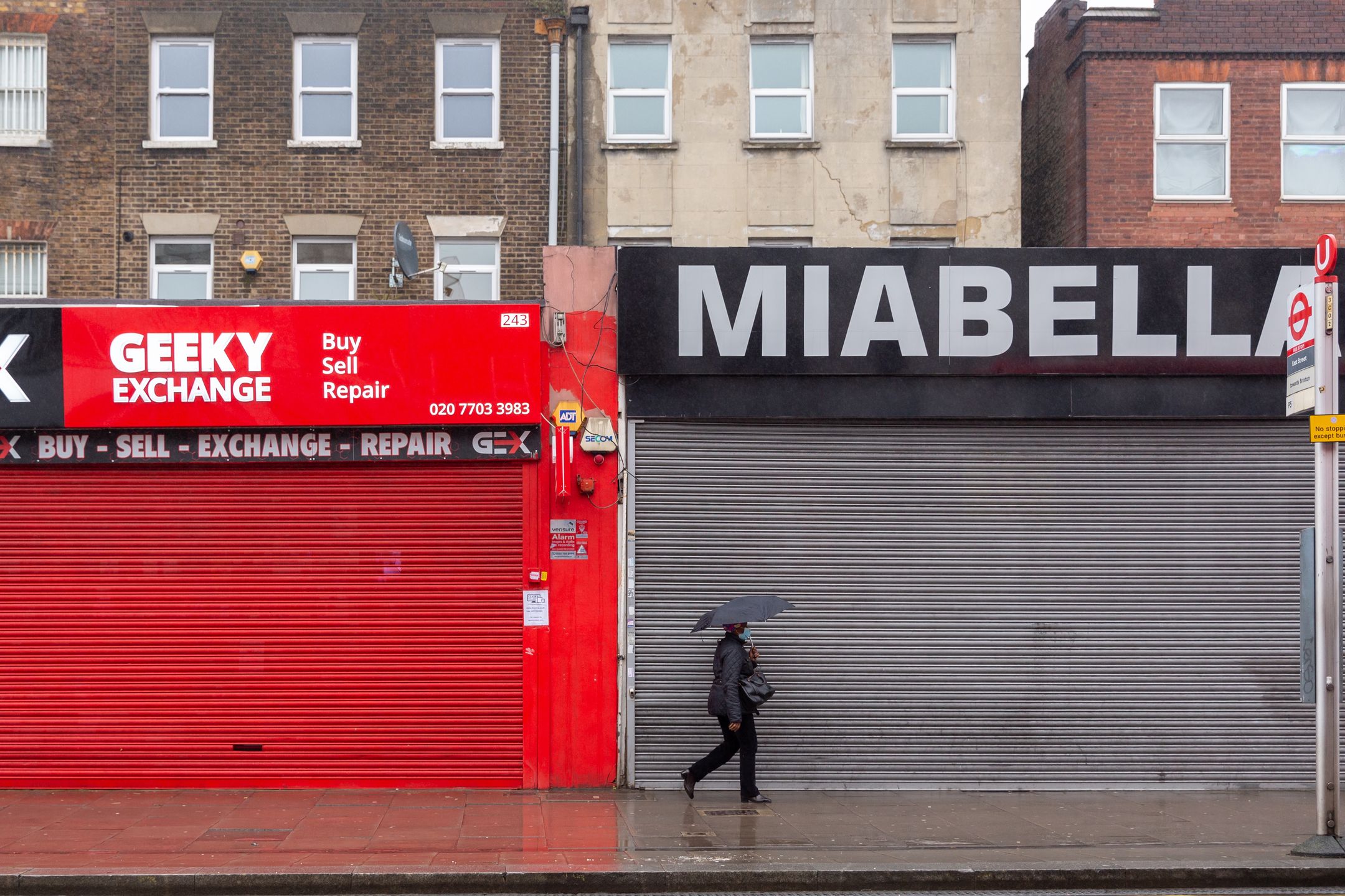 A Londoner in protective face mask is seen shopping for essential needs on a rainy day in Elephant and Castle district as the UK's government introduced strict Coronavirus restrictions earlier this month due to sharp increase in numbers of Covid-19 cases in the UK - London, England on January 13, 2021. Only essential shops can be opened. Exercising and going to work are exceptions for Stay at Home policy. (Photo by Dominika Zarzycka/NurPhoto via Getty Images)