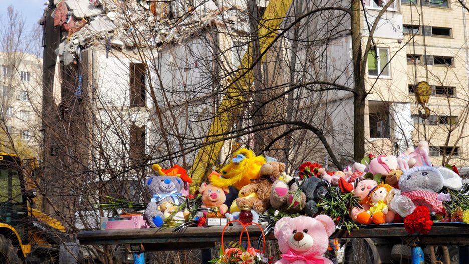 Mieszkańcy przynoszą kwiaty i zabawki pod zniszczony blok w Odessie