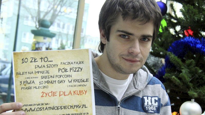 Kuba Bielak z plakatem, który ma mu pomóc zebrać pieniądze na przeszczep płuc