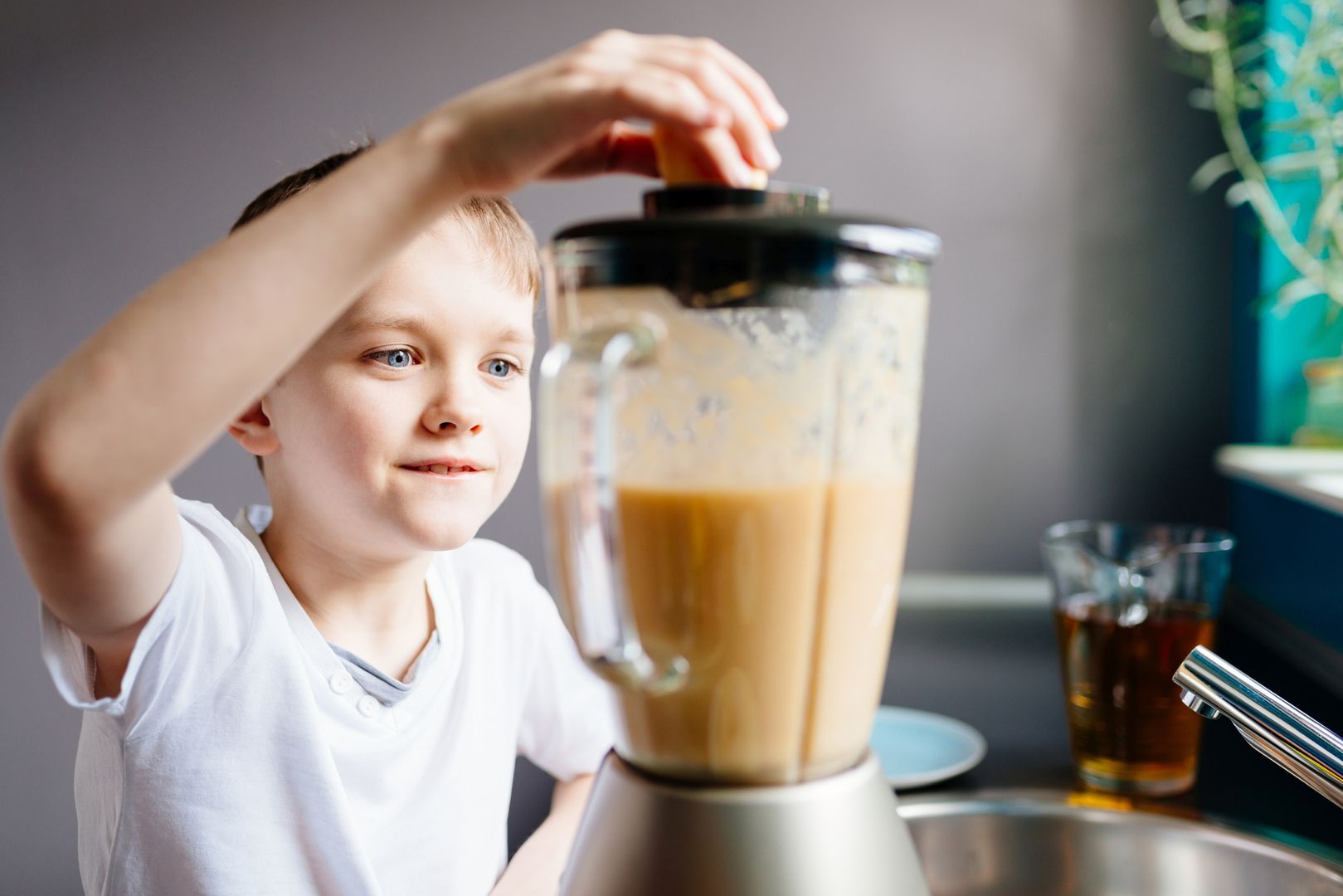 Happy little boy is making healthy fruit juice at home. Healthy eating 