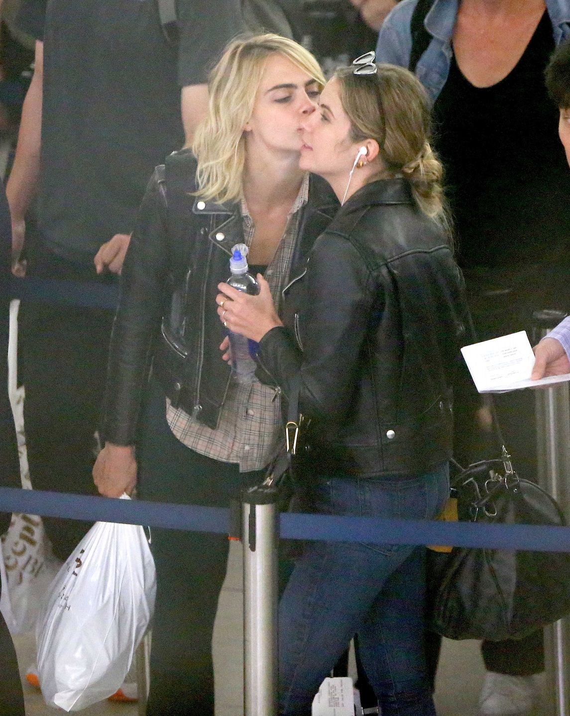 Cara Delevingne et sa petite amie Ashley Benson arrivent à l'aéroport JFK de New York le 18 juin 2019. Le couple échange des baisers derrière la file de sécurité. Cara Delevingne and girlfriend Ashley Benson are seen arriving at JFK airport in New York, on June 18th 2019. They have been spotted kissing each other in the security line.