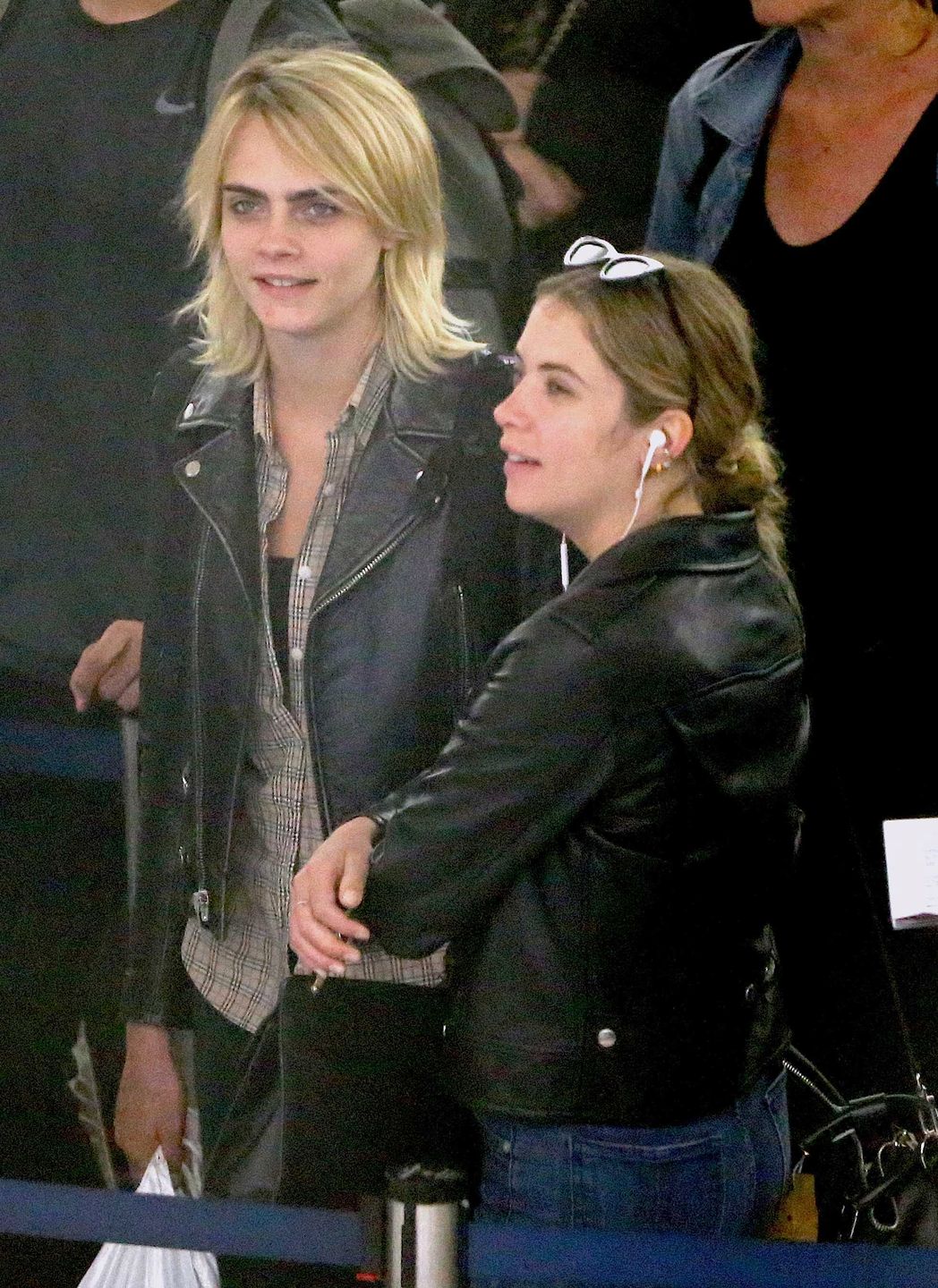 Cara Delevingne et sa petite amie Ashley Benson arrivent à l'aéroport JFK de New York le 18 juin 2019. Le couple échange des baisers derrière la file de sécurité. Cara Delevingne and girlfriend Ashley Benson are seen arriving at JFK airport in New York, on June 18th 2019. They have been spotted kissing each other in the security line.