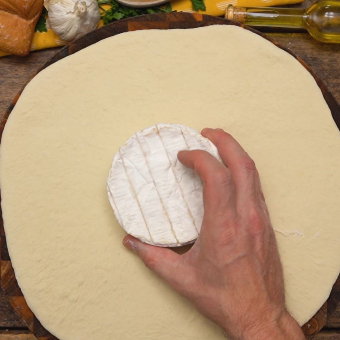 I arrange a piece of Camembert on the pizza dough.