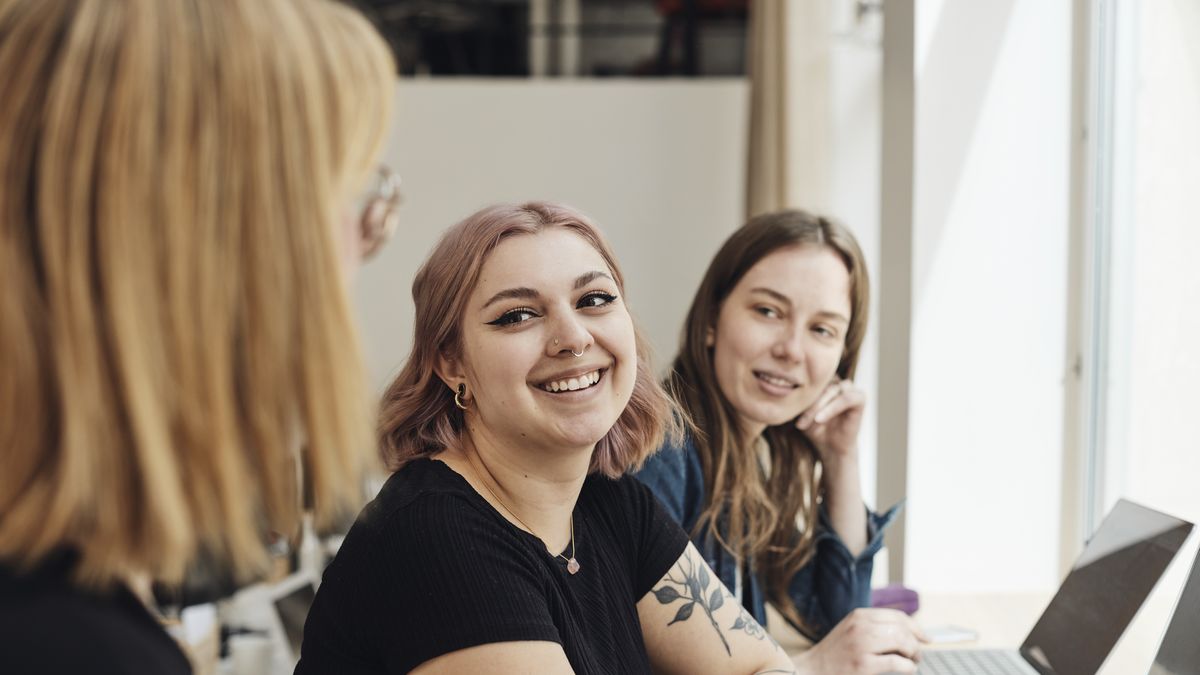 Smiling female entrepreneurs looking at colleague during meeting in office
Maskot