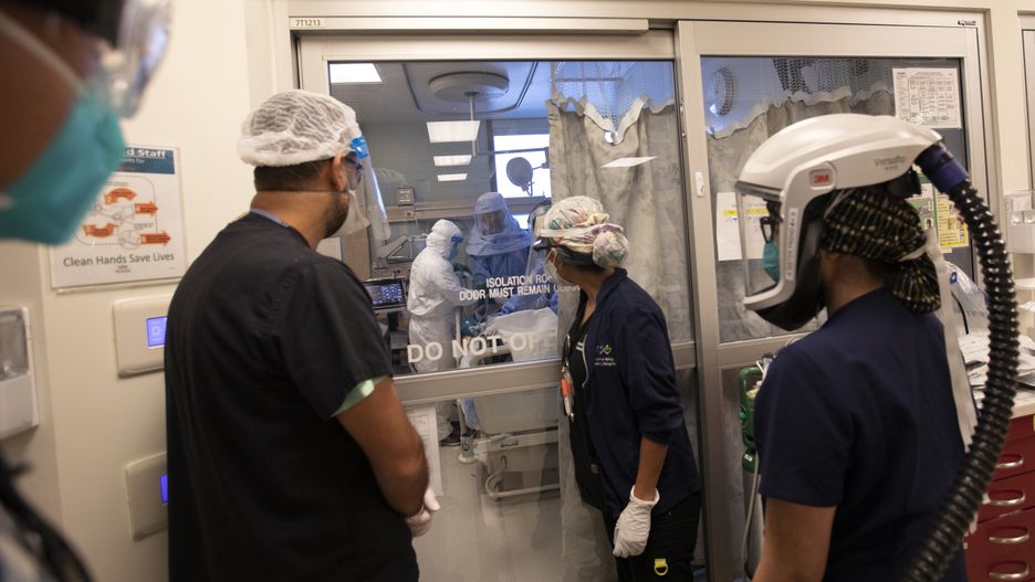 Inside Martin Luther King, Jr., Community Hospital during the global pandemicLOS ANGELES, CA - JANUARY 18, 2021: Visible through the sliding glass Desi Domingo,RT, left, Dr. Oscar Casillas, MD, middle, and Amanda Hamilton, RN, right, are working on Gilbert Torres, age 30, a covid possitive patient during the global pandemic inside Martin Luther King, Jr. Community Hospital on JANUARY 18, 2021 in Los Angeles, CA. (Francine Orr / Los Angeles Times via Getty Images)Francine Orrcovid, pandemic
