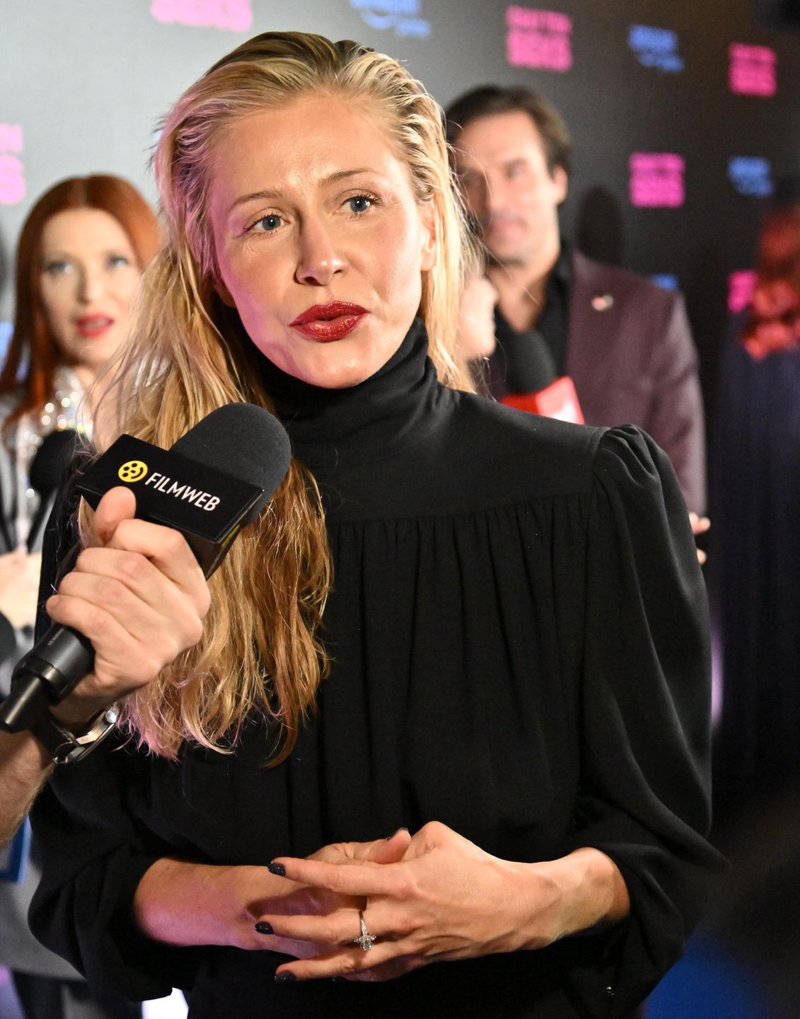 Katarzyna Warnke na premierze, w tle Piotr Stramowski