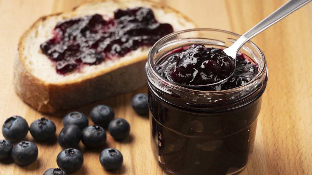 blueberry jam set against a wooden backdrop. Behind it, blueberry fruit and bread.
Spooning blueberry jam set against a wooden backdrop. Behind it, blueberry fruit and bread.
masa44