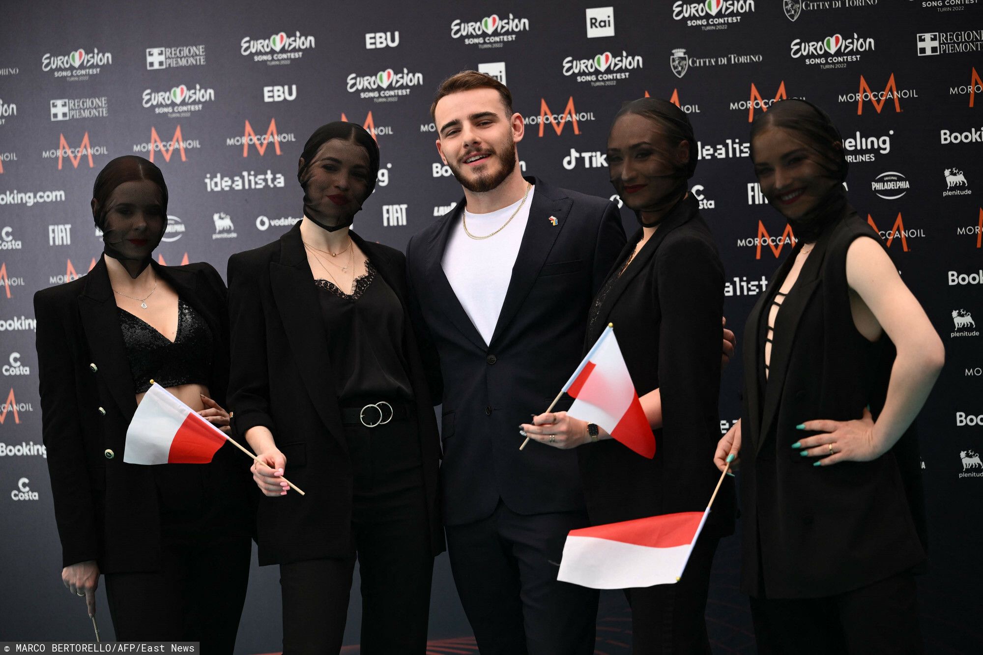 Krystian Ochman pozuje na turkusowym dywanie przed Eurowizją w Turynie