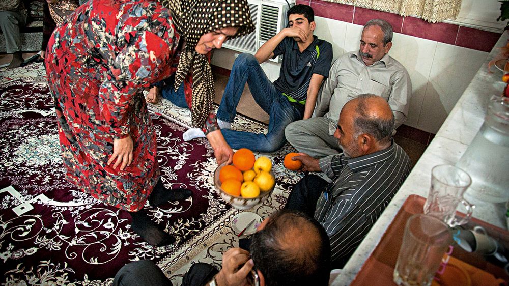 Ciotka Mohammada, Zahra rozdaje gościom owoce. Jednym z gości jest ojciec fotografa Jahanbakhsh