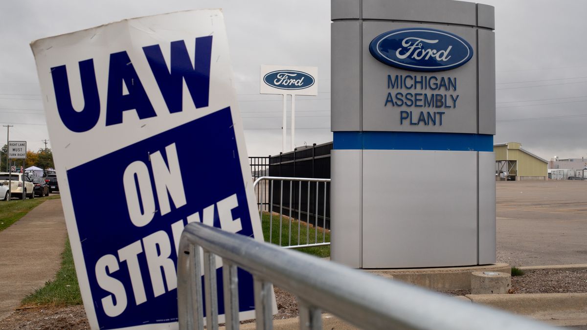 A "UAW On Strike" sign outside the Ford Motor Co. Michigan Assembly plant in Wayne, Michigan, US, on Tuesday, Sept. 26, 2023. President Joe Biden endorsed the United Auto Workers' demand for a major wage increase during a visit to a picket line at a General Motors Co. plant in suburban Detroit, a historic show of solidarity with organized labor. Photographer: Emily Elconin/Bloomberg via Getty Images