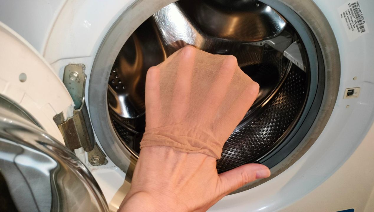 Nałóż rajstopy na dłoń i przetrzyj wnętrze bębna w pralce