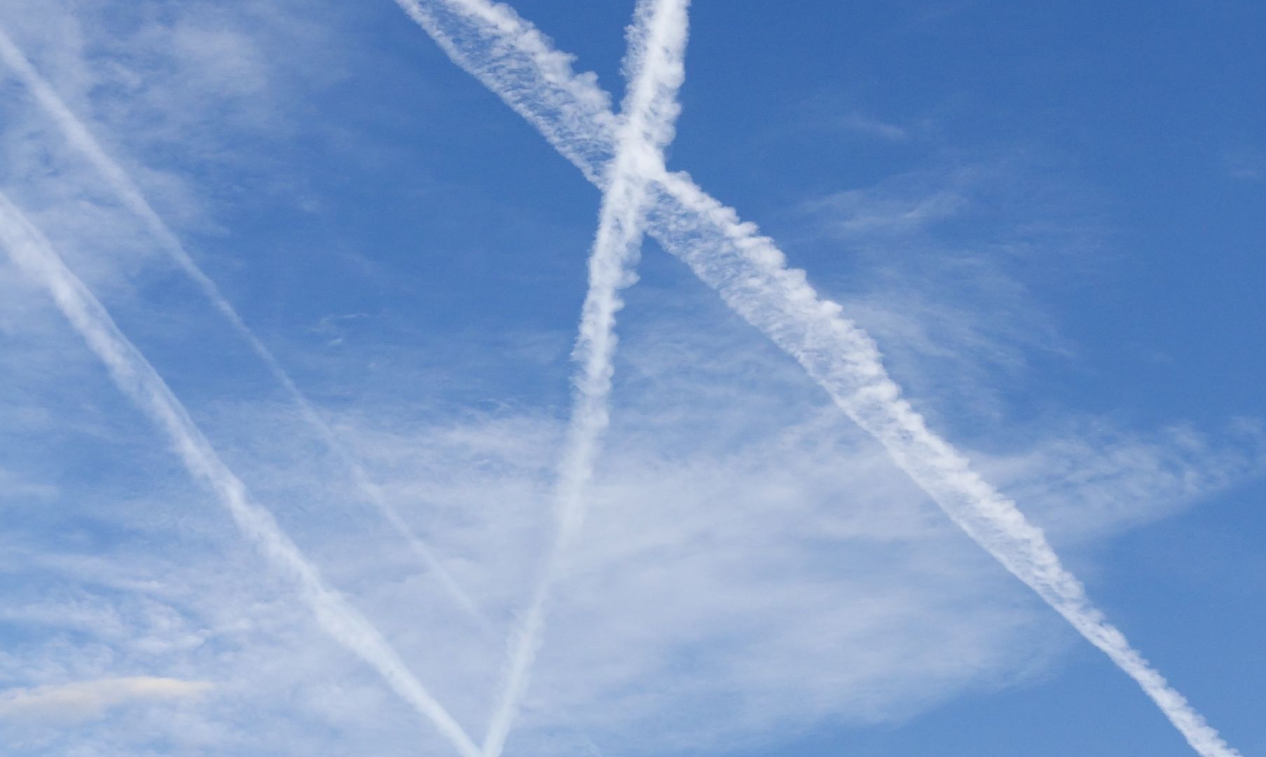 Blue sky with clouds and white airplane trace 