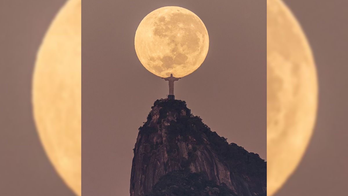 Statua Chrystusa Zbawiciela w Rio na tle ogromnego Księżyca.