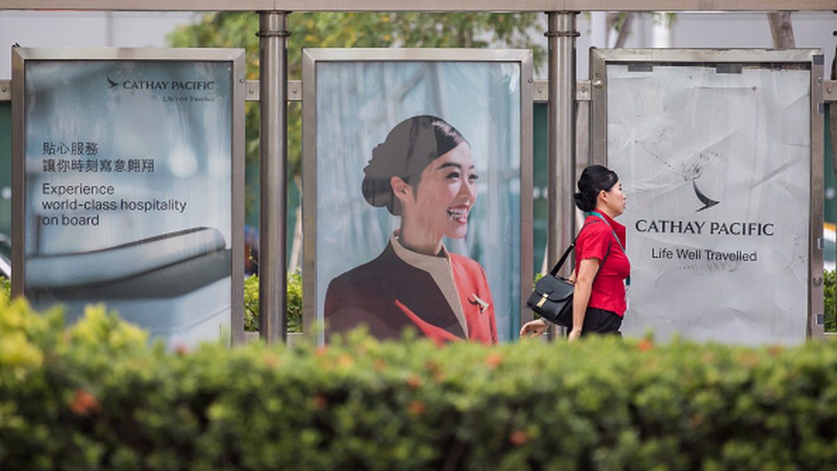 A Cathay Pacific Airways Ltd. employee walks past an advertisement for the company displayed at a bus stop in Cathay Pacific City, the company's headquarters, in Hong Kong, China, on Sunday, Aug. 5, 2018. Just when Hong Kongs flagship airline was showing signs of a rebound, crude oil played spoilsport again, denting early gains from a transformation plan that Chief Executive Officer Rupert Hogg considers crucial to survival. Photographer: Paul Yeung/Bloomberg via Getty Images
Bloomberg