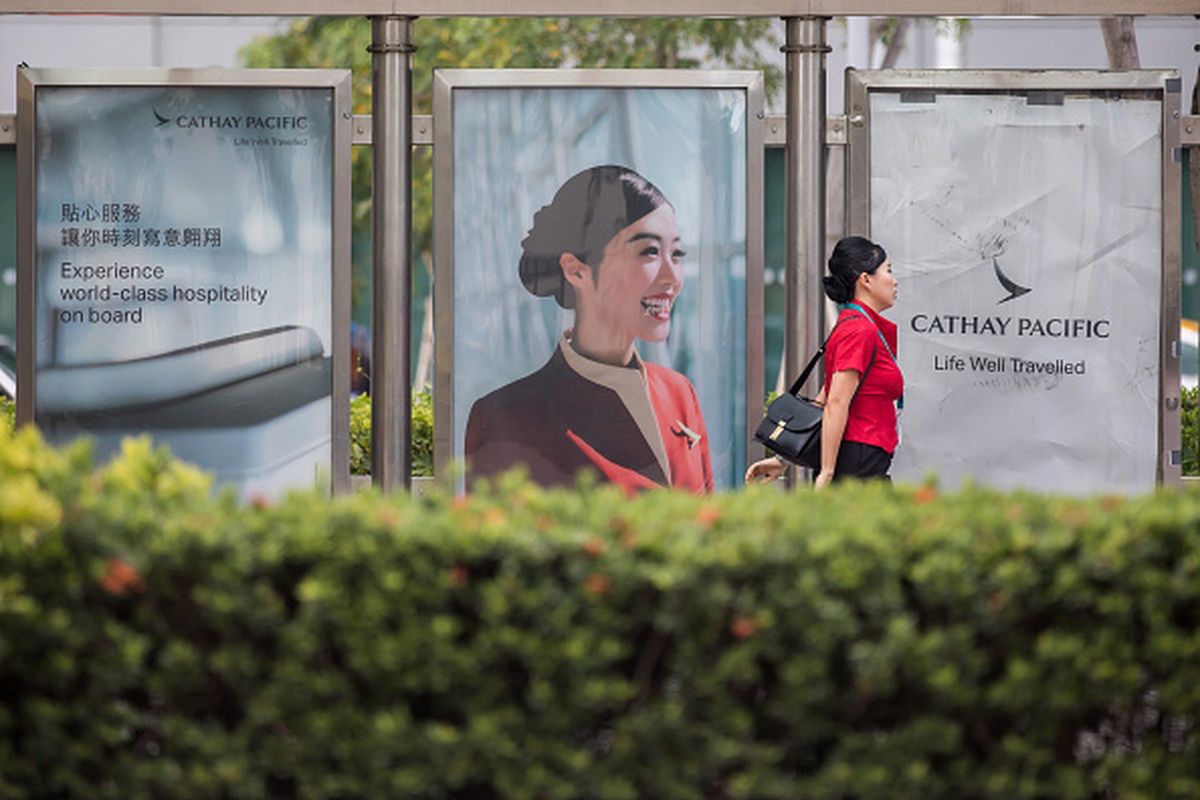 A Cathay Pacific Airways Ltd. employee walks past an advertisement for the company displayed at a bus stop in Cathay Pacific City, the company's headquarters, in Hong Kong, China, on Sunday, Aug. 5, 2018. Just when Hong Kongs flagship airline was showing signs of a rebound, crude oil played spoilsport again, denting early gains from a transformation plan that Chief Executive Officer Rupert Hogg considers crucial to survival. Photographer: Paul Yeung/Bloomberg via Getty Images
Bloomberg