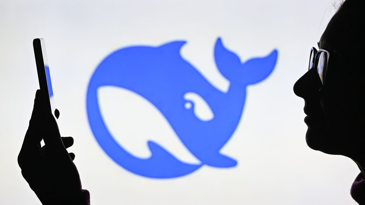 EDMONTON, CANADA - JANUARY 28: 
A woman holds a cell phone in front of a computer screen displaying the DeepSeek logo, on January 28, 2025, in Edmonton, Canada. (Photo by Artur Widak/NurPhoto via Getty Images)