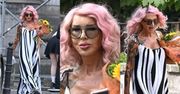 Ewa Minge w różowych włosach i pasiastej sukience przechadza się po mieście, dzierżąc słoneczniki (ZDJĘCIA)