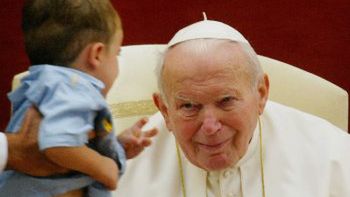 Papież błogosławi dziecko podczas modlitwy Anioł Pański w swej letniej rezydencji Castelgandolfo