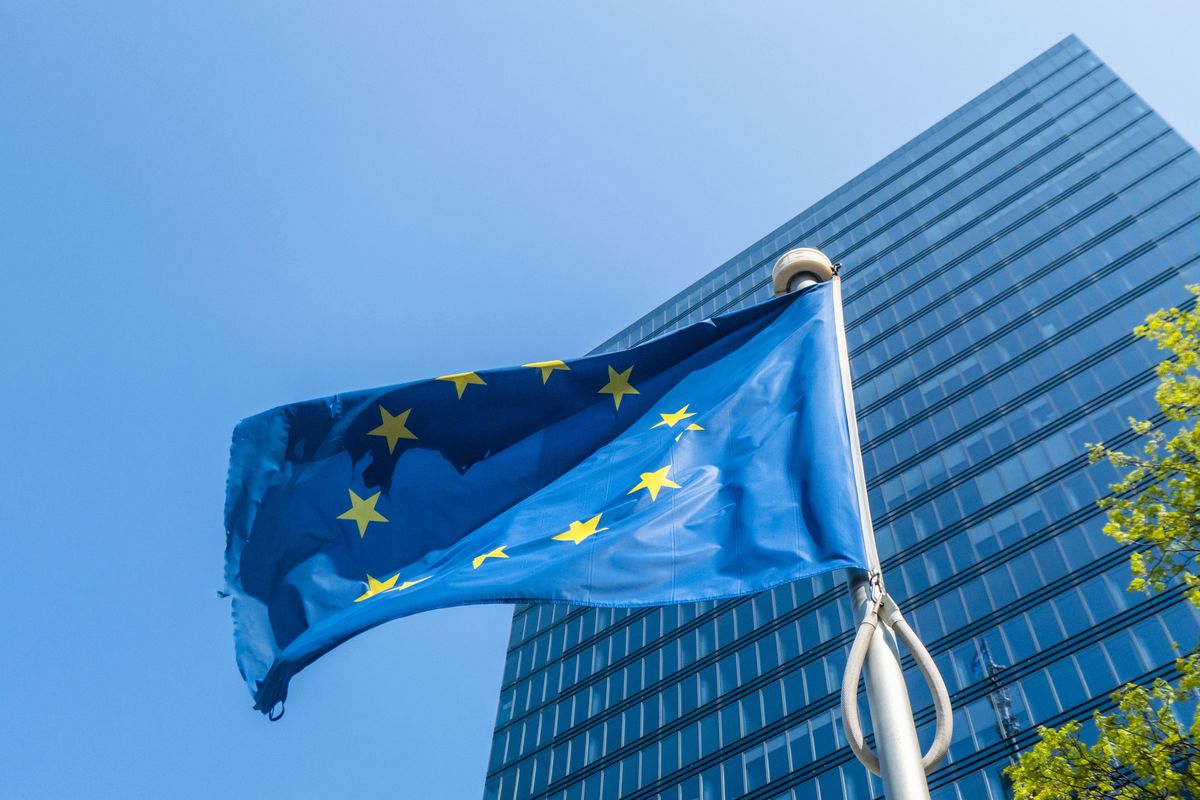 Flag of Europe on flagpole waving in the blue sky on a sunny day among the high buildings in the European capital city Brussels near Brussels North Railway station. The flag of Europe or the European Flag is the symbol of the Council of Europe CoE and The European Union EU as seen in the Belgian capital Brussel. Brussels, Belgium on April 24, 2022 (Photo by Nicolas Economou/NurPhoto via Getty Images)