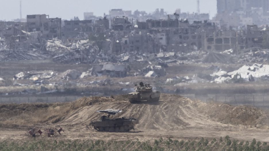 SOUTHERN ISRAEL, ISRAEL - MAY 13: Israeli tanks armored vehicle move along the border with the Gaza Strip as seen from a position on the Israeli side of the border on May 13, 2024 in Southern Israel, Israel. On Yom HaZikaron, Israel Memorial Day, Israeli society comes together to mourn fallen soldiers who died for the nation's independence, as well as civilian victims of terror. This year, from sundown on May 12 to sundown on May 13, the day of grief is marked by ceremonies held at military cemeteries across the country. Yom HaAtzmaut, Israeli Independence Day, follows in celebration. (Photo by Amir Levy/Getty Images)